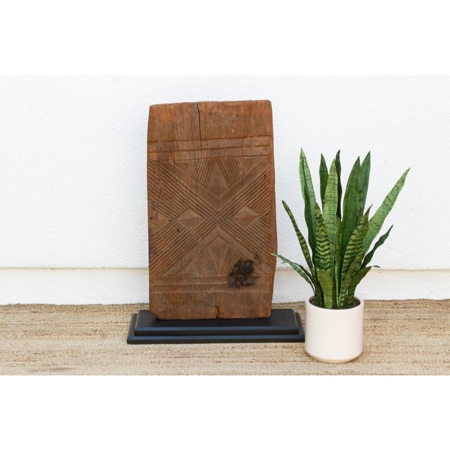 Hand-carved from a single plank of hardwood, this door carries Mali's Dogon or Bamana geometric tradition in a converging...