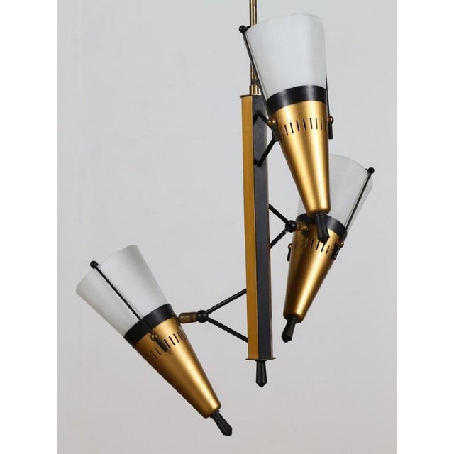 Vintage suspended lamp is a design lamp manufactured in Italy, circa 1950s. Elegant suspended three-lights lamp in...