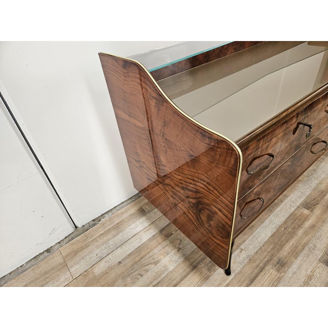 This 1950s-style chest of drawers exudes elegance and timelessness, crafted from walnut burl that highlights the wood's...