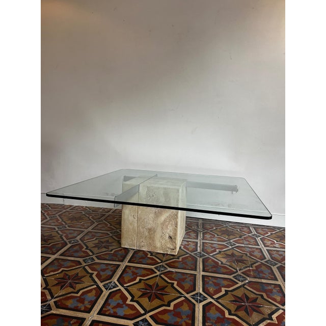 Elegant coffee table with a travertine base and a glass tabletop resting on chrome. Producer: Artedi Period: 1970s...