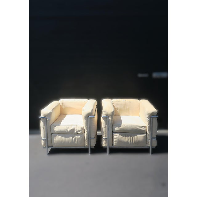 A substantial and beautifully made pair of LC2‑style modernist armchairs featuring polished tubular chrome frames and...
