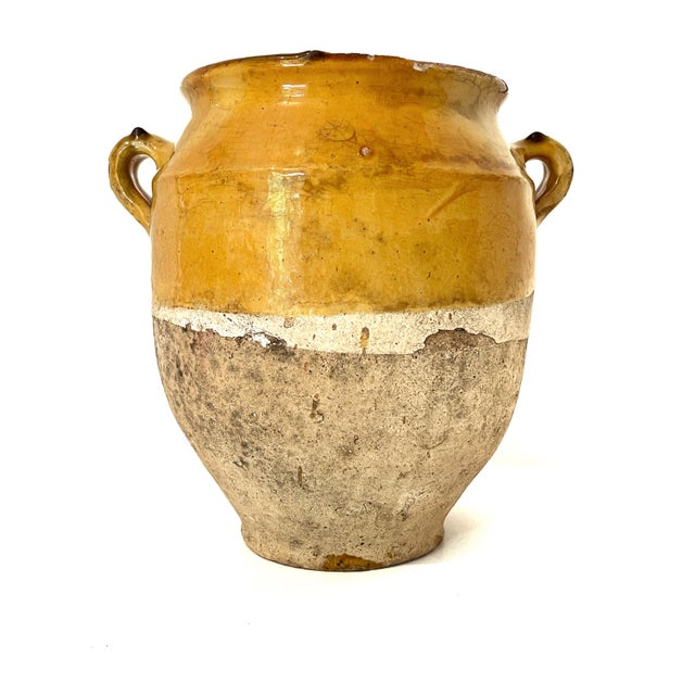 Antique French terracotta confit jar featuring a bright yellow or honey-colored glaze.
