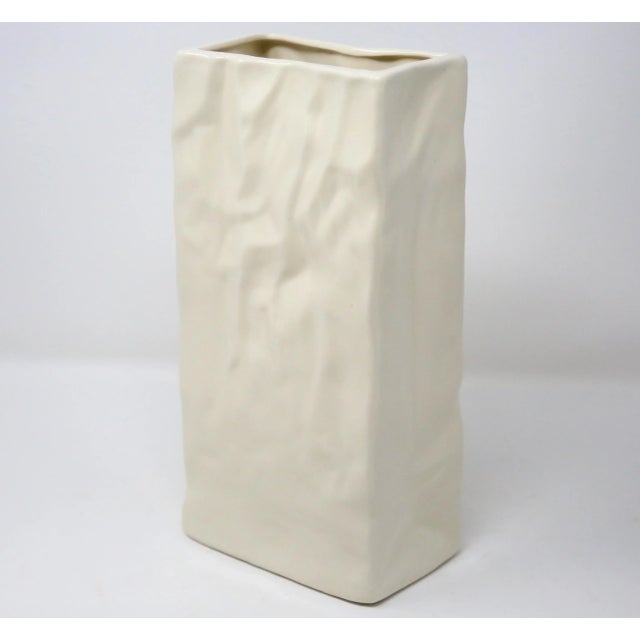 A beige ceramic vase, in the form of a crumpled paper sack.