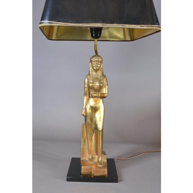 Egyptian Revival table lamp from the 1970s, with a standing gold-toned metal female figure in a stylized headdress and...
