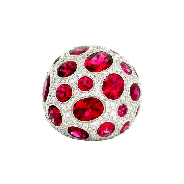 A captivating dome ring featuring 12.30 carats of round and oval rubellite. The rubellite stones exhibit a rich red hue....