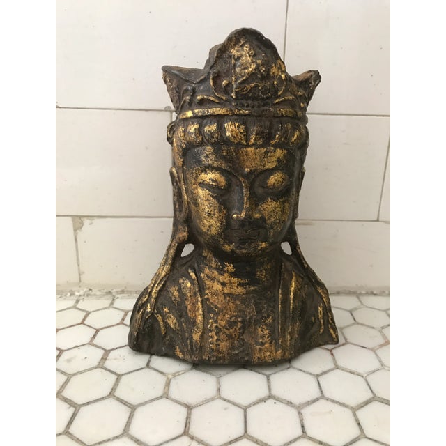 A cast iron gold-leafed statue of Chinese Quan Yin head. Some wear and rust.