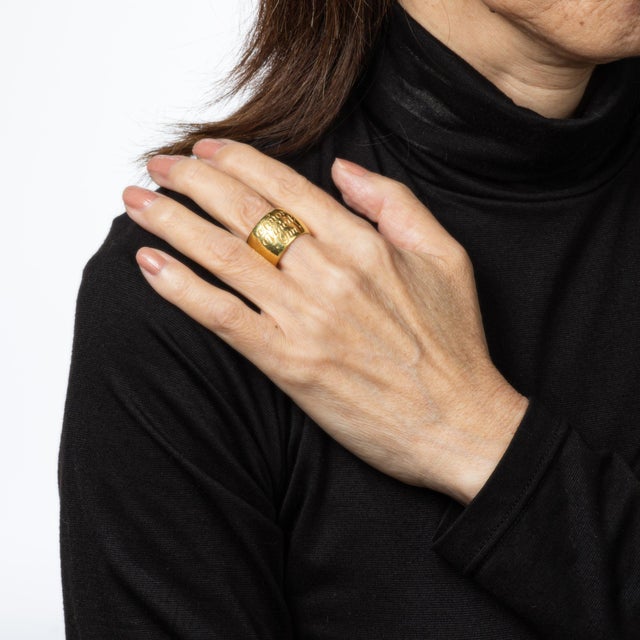 Stylish estate inscribed wide band ring crafted in 18 karat yellow gold. Made by British jewelry company Wright & Teague,...
