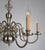 Eight-armed chandelier made of white brass decorated with an eagle and fish on top. The chandelier has undergone a...