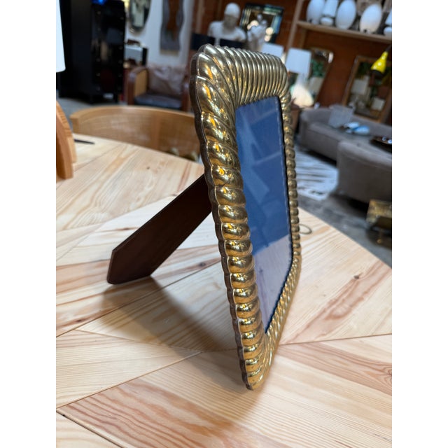 A decorative picture frame with a sculptural border of tightly twisted rope. Its warm gold-tone finish and generous...