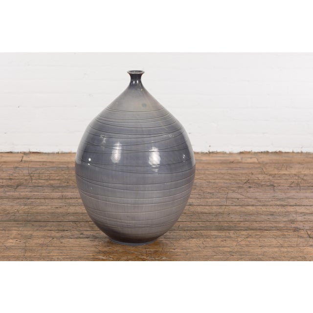A contemporary Prem Collection artisan hand crafted ceramic vase with narrow mouth, blue grey glaze and striated effects....
