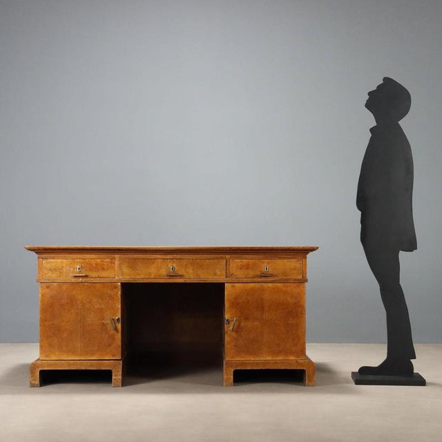 Art Deco desk in walnut and walnut burl. Three drawers in the lower section and side doors concealing three drawers. Brass...