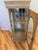 This 1980's Ethan Allen style blonde pier-curio cabinet with hand crafted wood details and two glass shelves is quite tall...
