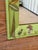 A charming vintage wooden wall mirror featuring a soft green painted frame adorned with colorful tropical birds,...