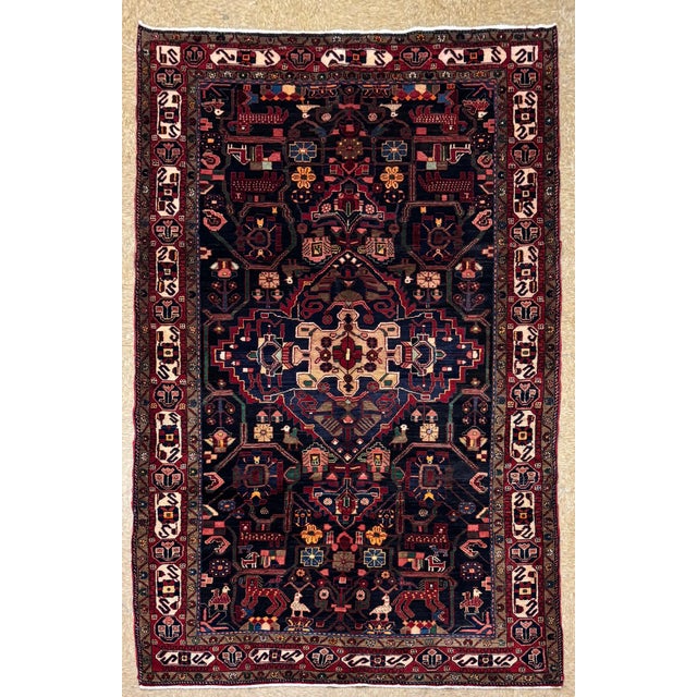Antique hand-knotted rug from the Nahavand region of western Iran, featuring a complex central medallion set within a dark...