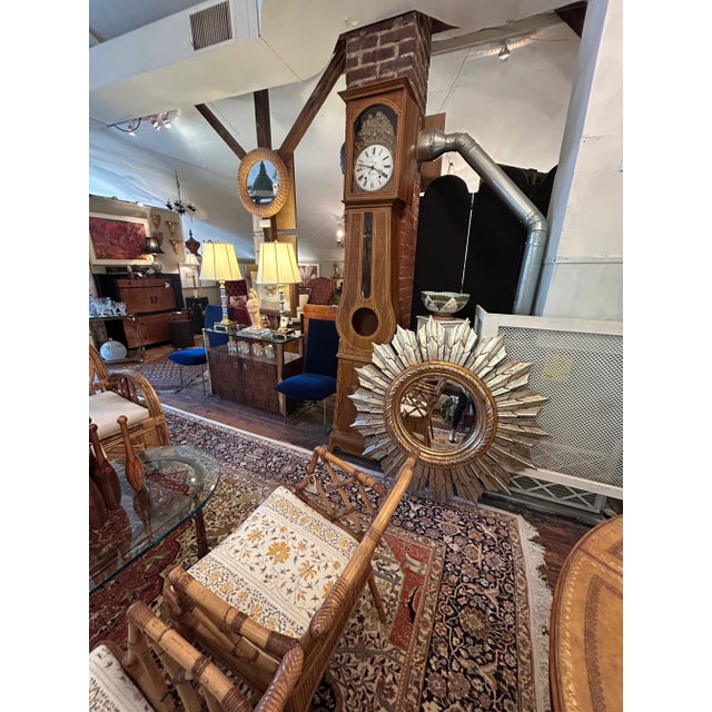 A focal point statement mirror in a super sized scale, intricately carved and gilded in silver and gold, with interior...