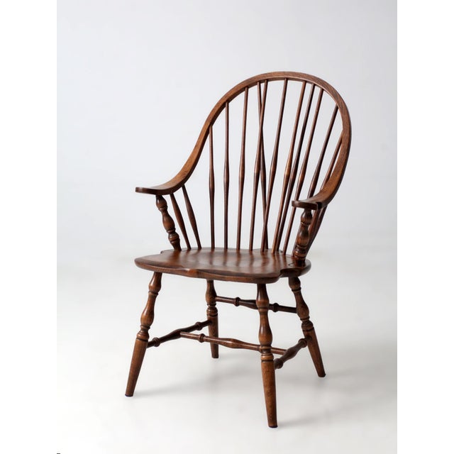 This antique American Windsor armchair features a classic brace-back design with a graceful bow crest, slender spindles,...