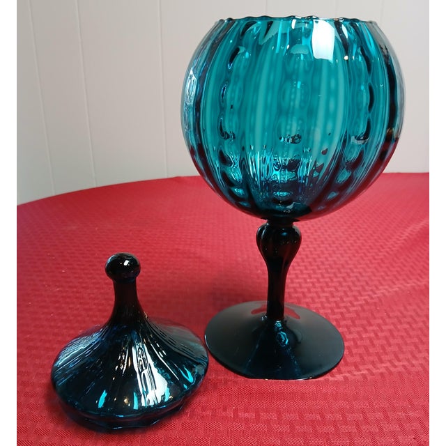 This stunning vintage apothecary jar is crafted from vibrant turquoise glass featuring a optic rib pattern, that creates a...
