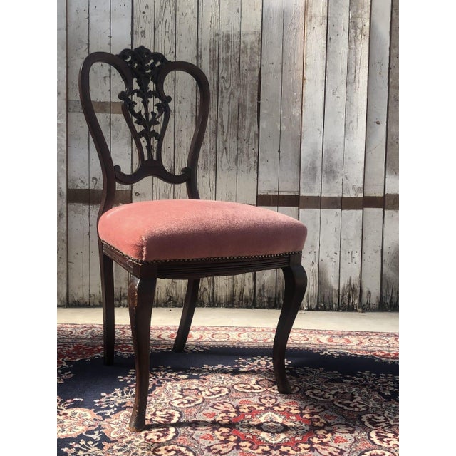 A charming set of four mid-20th-century Chippendale-style dining chairs, featuring elegantly carved backrests, cabriole...