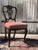 A charming set of four mid-20th-century Chippendale-style dining chairs, featuring elegantly carved backrests, cabriole...