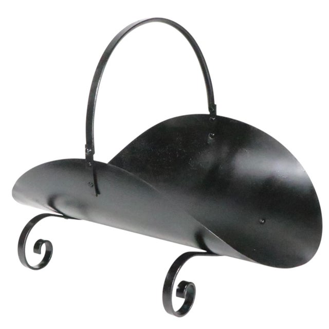 Decorative metal log holder, with curved bed on curlicue form legs, and a swing style handle. This example is in new black...