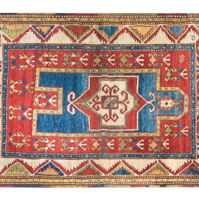 A striking early 20th-century Kazak prayer rug, this piece showcases the bold geometric artistry and rich color palette...