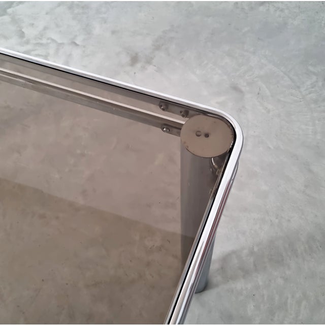 Vintage Midcentury Modern Italian Design Tubular Chrome & Smoke Glass Dining Table from the 1970s. This elegant table...