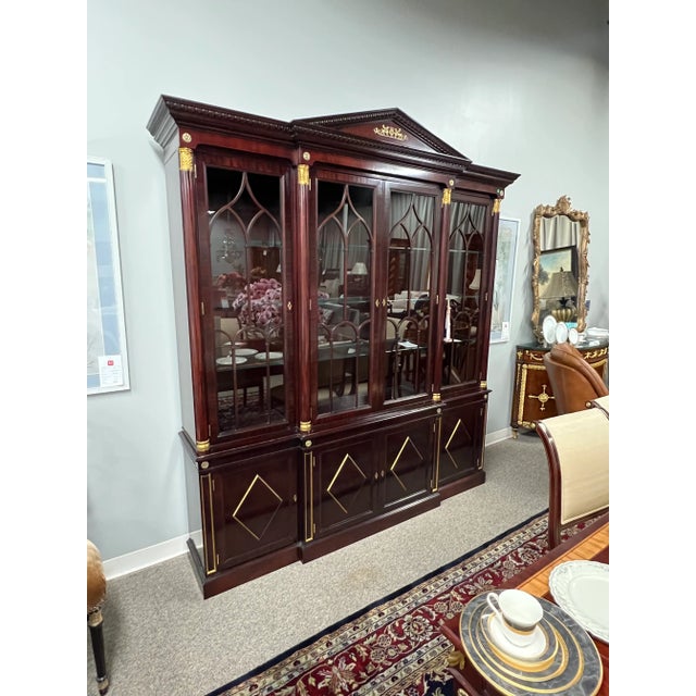 This distinguished china cabinet is surrounded by a substantial crown molding inset with a carved egg-and-dart molding....