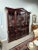 This distinguished china cabinet is surrounded by a substantial crown molding inset with a carved egg-and-dart molding....