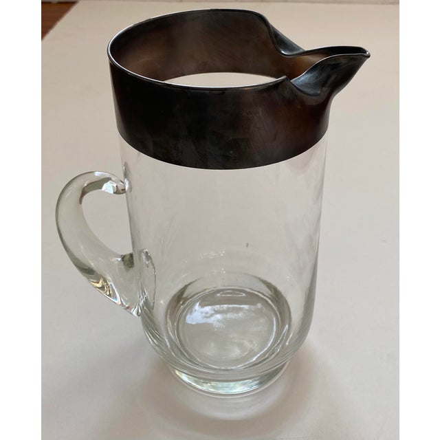 A vintage Dorothy Thorpe glass pitcher with Silver Band Rim and handle. Size: 9.5 inches H x 7.5 inches L 4.75 inches D
