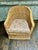 A charming vintage wicker club chair featuring an inviting barrel-form silhouette, generous proportions, and beautifully...