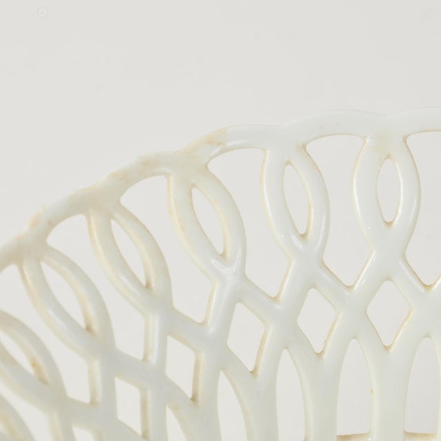 An incredible fine porcelain footed basket with lattice and lion paw details. Has one small chip and a couple of hairline...