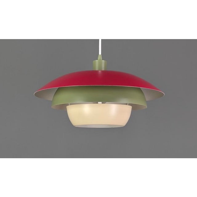 A playful and uncommon Danish pendant lamp from the 1970s, combining a red, olive and cream outer shades. Its layered...