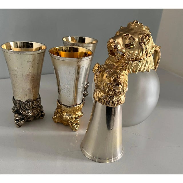 In the Style of Gucci and Ralph Lauren we have four lion stirrup cups and a lion head pitcher of frosted bulb glass. The...