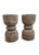 The hourglass form has been executed in teak a thousand times. This pair gets it right. The weathered surface — silvered...