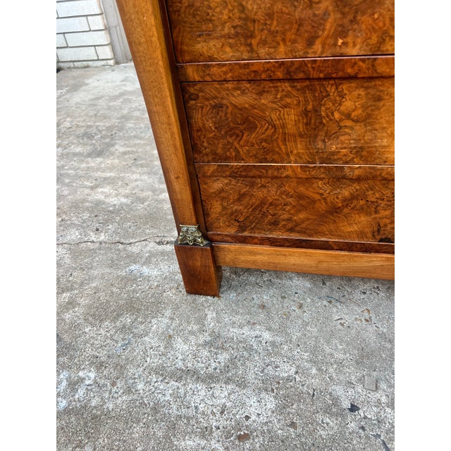 Striking French 19th-century Empire commode featuring richly figured burl walnut veneer, four drawers, and a dramatic dark...