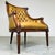 A beautiful oversized tufted leather high-back lounge chair in the Louis XVI style having intricate carvings throughout...