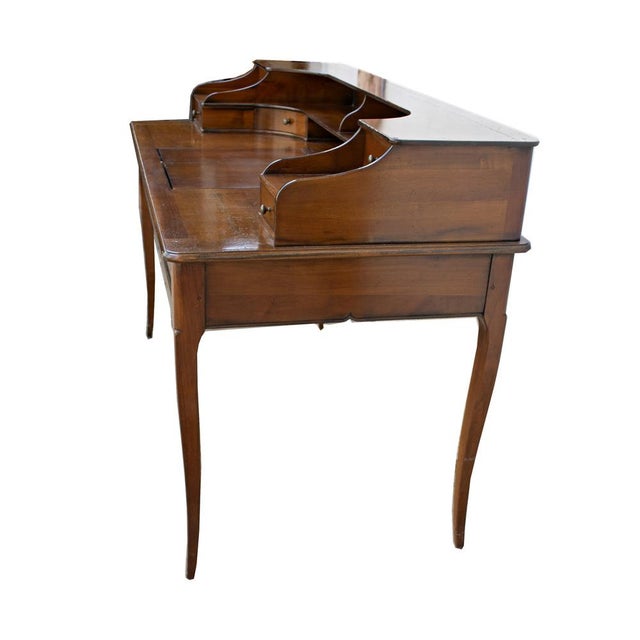 Desk crafted entirely from solid cherry and poplar wood. The rectangular top features a lift-up central drawer, typical of...