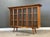 A mid century modern walnut bookcase with three doors, walnut shelves and long canted legs. Excellent condition. Circa...