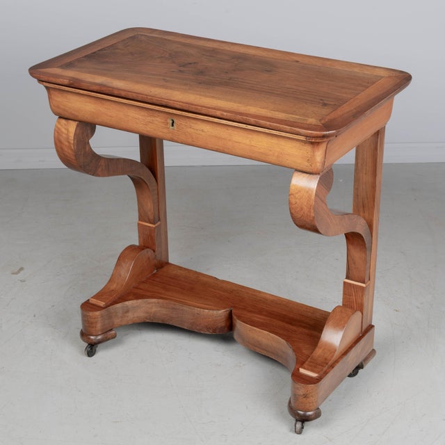 A 19th century French Louis-Philippe console made of solid walnut and veneer of walnut. Sculptural scrolled front legs...