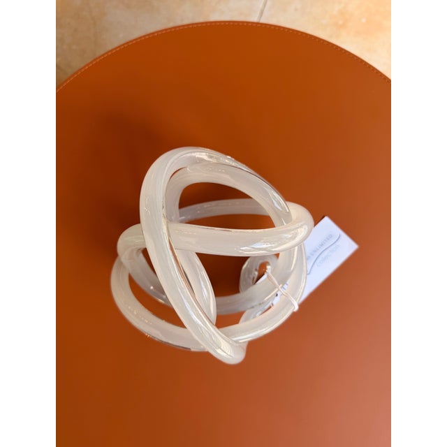 Contemporary decorative glass sculpture featuring an elegant interlocking knot design that adds sculptural interest to any...