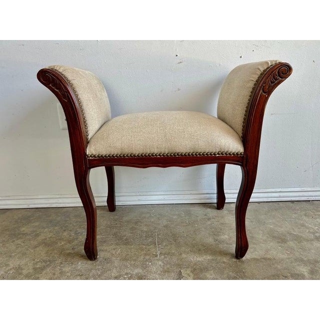 Charming petite French Provincial style bench that is newly upholstered in Belgium linen and detailed with brass nailheads.