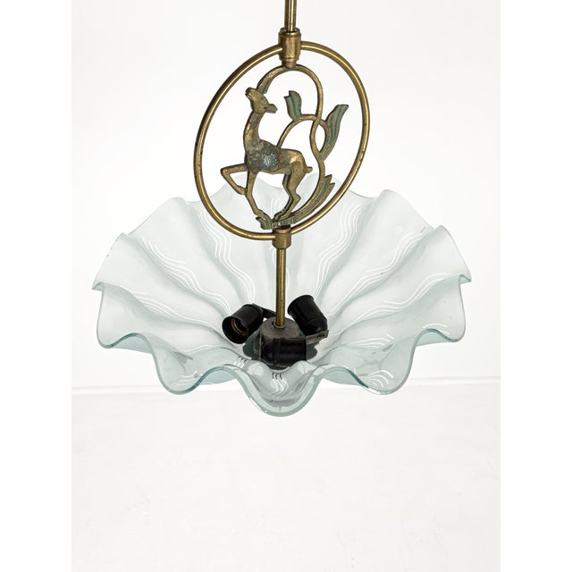 An elegant Swedish Art Deco pendant light produced during the 1930s, featuring a beautifully cast brass frame centered by...
