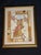 Decorative Asian-inspired framed artwork featuring a traditional figure with calligraphy-style background details and warm...