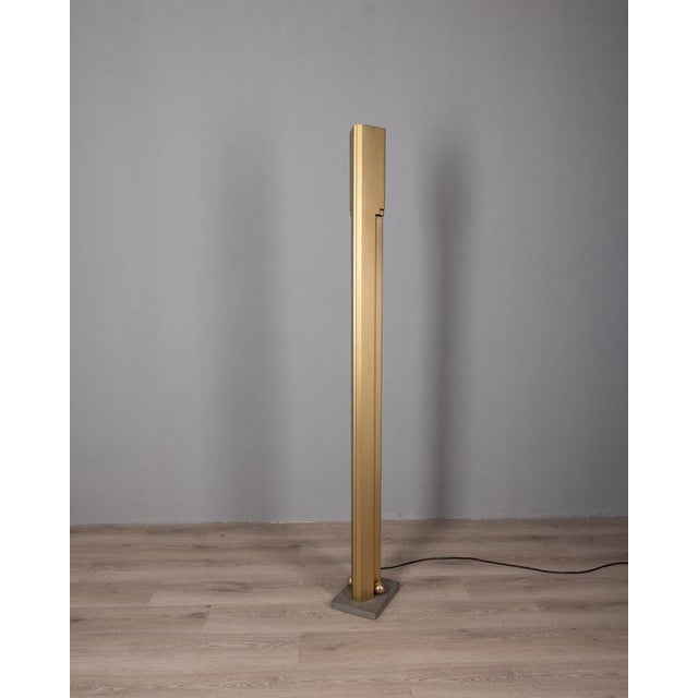 Sculptural floor lamp with marble base and brass spheres, golden satin metal structure, there is a dimmer switch that...