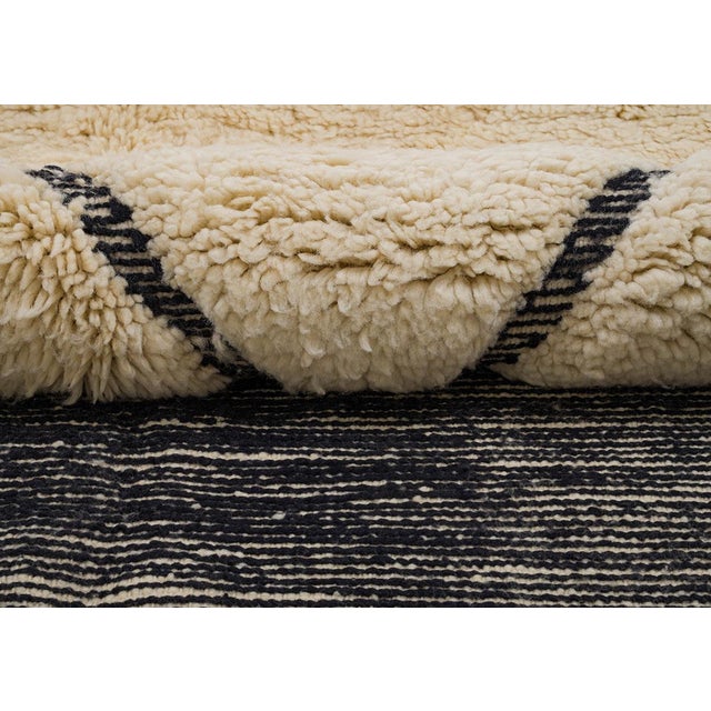Bold blocks of charcoal and warm orange play against a soft ivory field, punctuated by a single graphic chevron — modern,...