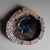 Italian ceramic plate with a wide rim, decorated with scenes in prehistoric forms and a stylized peacock bird in the well....