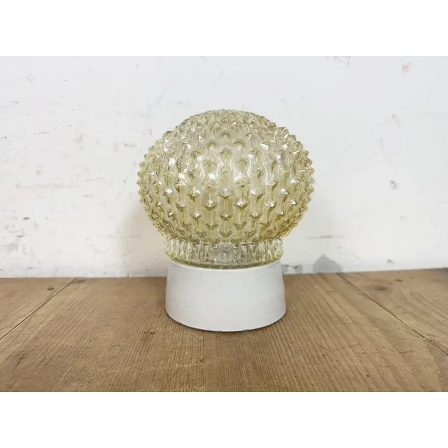 Vintage industrial ceiling or wall light made in former Czechoslovakia during the 1970s. It features a white porcelain...