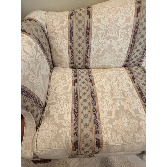 Elegant vintage Chippendale-style camelback sofa featuring a sweeping, classic silhouette perfect for traditional...