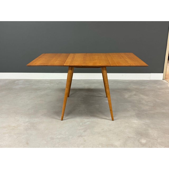 A mid century modern solid maple drop leaf dining table designed by Paul McCobb for Winchendon’s Planner Group....