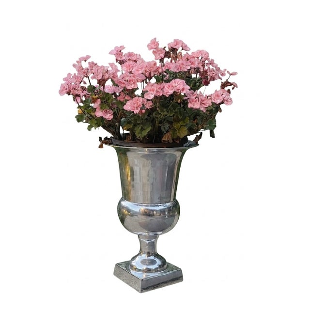 A striking pair of large pedestal urns crafted in substantial polished aluminum. With the Polished Aluminum Urns, bring...